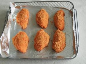 腌制好了鸡翅，准备好咸蛋黄风味调料。带着手套拿起一只鸡翅，裹上厚厚一层咸蛋黄调料。然后排入烤篮，记得垫上锡纸。