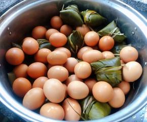 蒸锅底摆上粽叶防止粘锅依次摆上粽子再摆上一层鸡蛋最好是一个挨一个夹紧的摆放这样蒸出来粽子更紧实