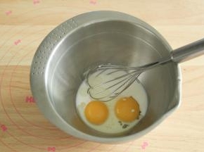 蛋黄放入无水干净盆中，倒入牛奶、酸奶和玉米油，用蛋抽搅打均匀。