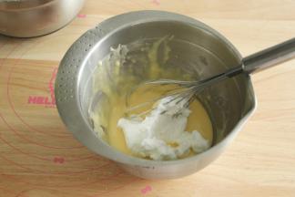 取1/3蛋白霜到蛋黄糊中，左手配合逆时针转盆，右手用蛋抽从2点钟方向切入，沿着盆底往盆边翻起到盆中心，重复切拌，翻拌动作，初步混匀。再取1/3蛋白霜，重复上一步动作，拌匀。