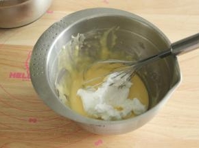 取1/3蛋白霜到蛋黄糊中，左手配合逆时针转盆，右手用蛋抽从2点钟方向切入，沿着盆底往盆边翻起到盆中心，重复切拌，翻拌动作，初步混匀。再取1/3蛋白霜，重复上一步动作，拌匀。