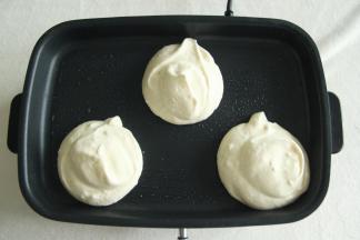 然后用大勺子、裱花袋或者冰淇淋勺，挖一勺放入热好的平底锅中，一勺倒好，再追加一勺，堆叠起来的2勺面糊。