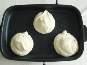 然后用大勺子、裱花袋或者冰淇淋勺，挖一勺放入热好的平底锅中，一勺倒好，再追加一勺，堆叠起来的2勺面糊。