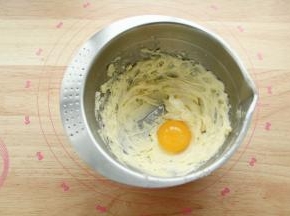 用刮刀稍微混合一下，看不见糖粉即可，防止打发时候糖粉飞溅。用电动打蛋器中速顺一个方向进行打发。打到黄油变白，蓬松羽毛状。如图，体积明显变大，盆边的用刮刀刮下，要全部打到。然后加入一个常温蛋黄。