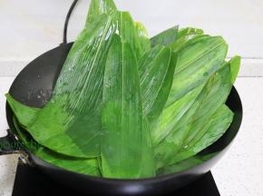 粽叶清洗干净之后，用剪刀把叶子的头和尾，剪掉。锅里倒入适量的水，煮沸之后，放入粽叶汆烫捞出，沥干水放凉。我用的是粽叶呀，芭蕉叶要回老家的院子才有，粽叶可以买到。