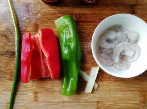 鲜虾买回，去壳剥出虾仁，去虾线！我买的是很大只的虾，剥出的虾仁还挺大只的。青红椒去柄去籽，然后清洗干净备用。葱姜也要清洗下哦。