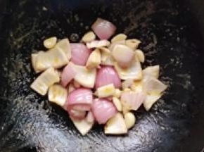 7.再加少许的油下入洋葱，蒜头炒几分钟