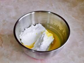 取三分之一的蛋白霜加入蛋黄糊器具中，用硅胶铲翻拌均匀。