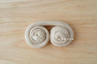 从面条的两端卷起来，再上下叠在一起。