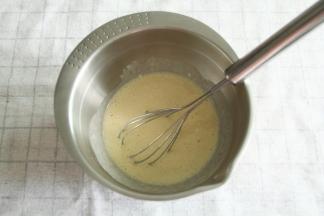 搅打均匀后倒入干净盆中。方便舀面糊。淋入10克蜂蜜，继续搅打均匀。然后用保鲜膜贴面静置5分钟。