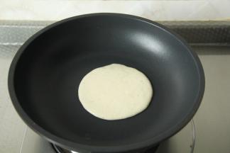 干净无油不粘锅，开小火热锅，然后用勺子舀入一勺面糊。一次性快速倒入，会自动摊平的。速度略微快一些。一次倒足！不要二次加面糊，受热不均匀，上色不好看。