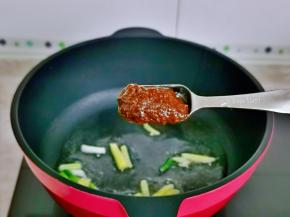 起油锅，加入葱姜煸炒，再加入一勺豆瓣酱煸炒。