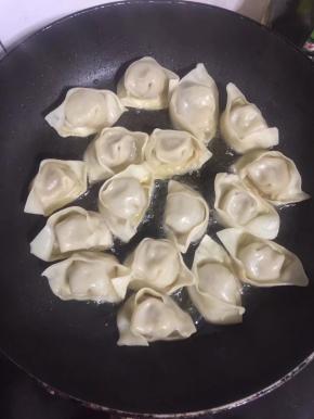 平底锅烧热倒入适量的油，放入蒸饺小火慢煎！