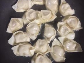 平底锅烧热倒入适量的油，放入蒸饺小火慢煎！