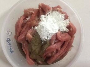 切好的里脊肉中加入两勺料酒，两勺生抽，两勺玉米淀粉，一勺胡椒粉。




