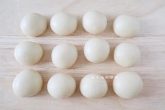 取一个水油皮压扁，包入一个油酥，捏紧收口，全部包好