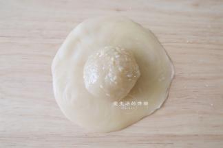 把刚分好大的馅包入里面，捏紧收口后朝下压扁成饼状