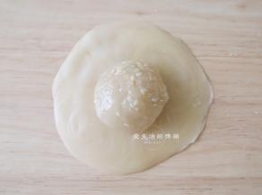 把刚分好大的馅包入里面，捏紧收口后朝下压扁成饼状