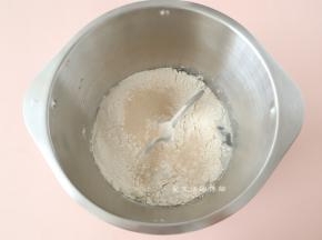 把面包体的材料倒入揉面桶里，迷迭香和橄榄油一起倒入搅拌。