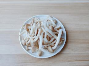 蟹味菇去除底部不能吃的位置，掰开放在淘米水中清洗2边再过清水冲洗干净沥干水分。