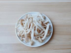 蟹味菇去除底部不能吃的位置，掰开放在淘米水中清洗2边再过清水冲洗干净沥干水分。