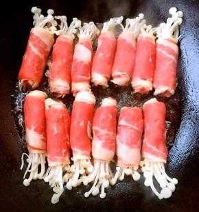 锅中倒入底油加热摆入金针菇肥牛卷中火煎起来