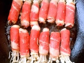 锅中倒入底油加热摆入金针菇肥牛卷中火煎起来