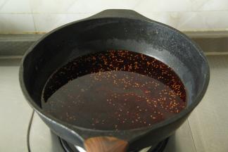然后将钵钵鸡红油拌菜调料中的酱包和红油包取出，倒入干净锅里，倒入450克清水，开大火煮开备用。