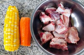 准备原材料新鲜的排骨在清水中浸泡一会儿玉米是煮好的胡萝卜去皮