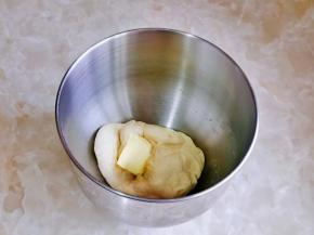 揉至面团扩展阶段时加入黄油，再次启动厨师机3档，揉一个小程序即可，这款小面包对手套膜的要求不是特别严格，用手撑开光泽透明即可。
