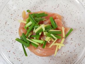 将切好的鸡肉条放入盆里，加入小葱段和生姜丝抓捏均匀。