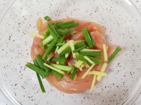 将切好的鸡肉条放入盆里，加入小葱段和生姜丝抓捏均匀。