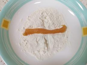 将腌制好的鸡肉条放入面粉里面沾上一层面粉。