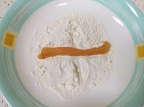 将腌制好的鸡肉条放入面粉里面沾上一层面粉。