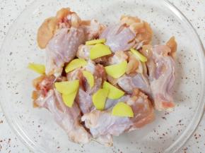 将处理好的鸡翅根放入盆里，放入生姜片搅拌均匀。