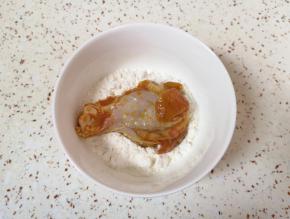 腌制好的鸡翅根取出，放入面粉里面打个滚。