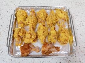 炸篮里铺上锡纸，将做好的鸡翅根摆在锡纸上（有两个鸡翅根没有裹面包糠，是直接腌好的，老公喜欢不裹其它食材的鸡翅根）。