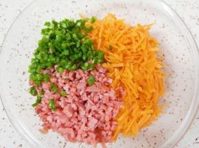 将胡萝卜丝、火腿肠碎和小葱碎一起放入大一点的盆里。