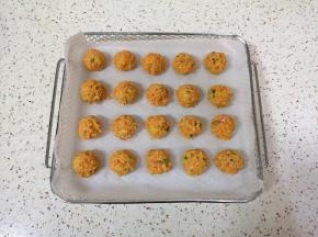 炸篮里铺上油纸，用手团好胡萝卜丸子，摆在油纸上。