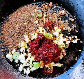 锅中倒入底油加热放入花椒八角孜然炸香再放入葱姜蒜爆香放入郫县豆瓣酱