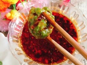 取一个豆角丸子，蘸上浇汁儿即可享用美味啦！