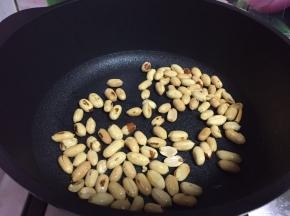 随后倒入花生米炒至变黄酥脆盛出备用