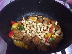 迅速倒入鸡块、彩椒块、花生米快速炒匀出锅