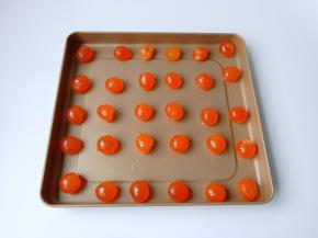 浸泡好的蛋黄用勺子一个个码在不粘烤盘上面，留一点间隙，喷一点白酒去腥。