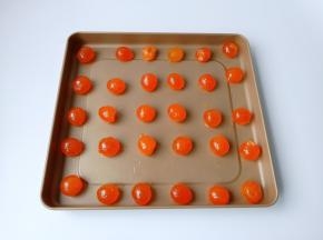 浸泡好的蛋黄用勺子一个个码在不粘烤盘上面，留一点间隙，喷一点白酒去腥。