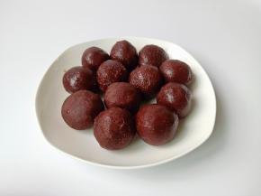 豆沙揉成圆球形状，放在手心按扁一点包上蛋黄揉圆备用。