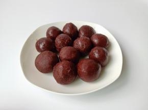 豆沙揉成圆球形状，放在手心按扁一点包上蛋黄揉圆备用。