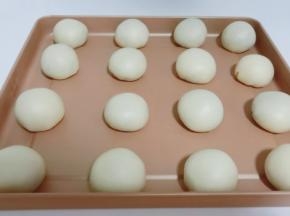 醒发好的面团对折捏好，擀成圆片包上馅料，面团轻轻往上挤好，揉圆再依次码到烤盘上。