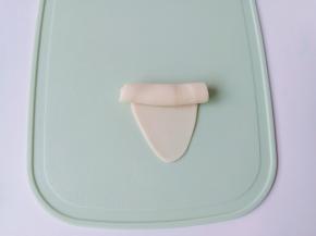 水油皮放在手心，包裹上油酥，慢慢推水油皮把油酥包上，收口揉圆放在案板上，用擀面杖擀面杖擀成如图形状再从上到下卷起来。