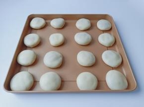 醒发好的面团两边对折再包上馅料，揉圆按扁码在烤盘上。【喜欢糯米馅的可以用糯米、黄油、白砂糖与清水来制作馅料】